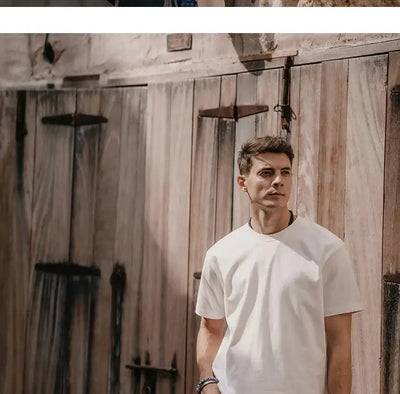 Man wearing a Superdry vintage t-shirt leaning against wooden doors, showcasing retro style and comfort.